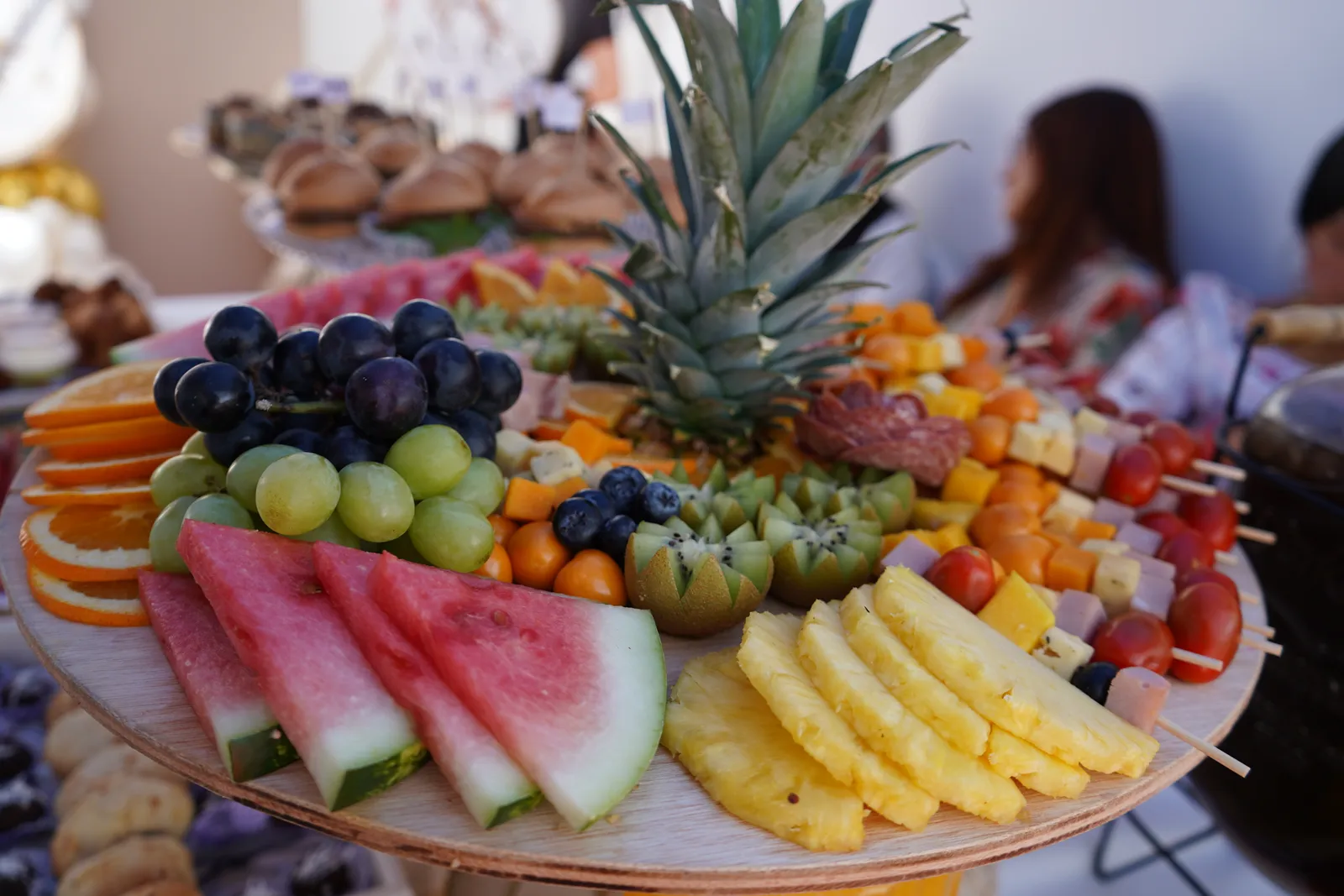 Detalle del catering: bandeja de fruta fresca con piña, uvas, sandía y kiwi